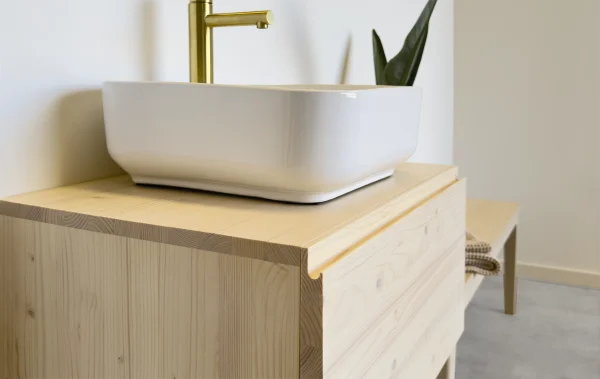 Mueble de baño de madera natural. Tirador uñero integrado en el diseño del mueble. Diseño nórdico.