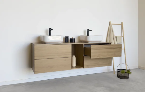 Mueble de baño en madera maciza de roble natural. Cuenta con cuatro cajones amplios y un hueco central abierto, perfecto para añadir un toque decorativo y personal a tu espacio
